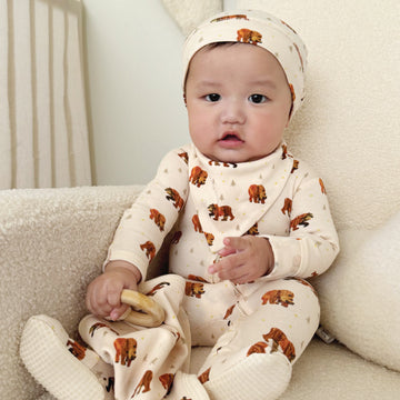 A child wearing an outfit from the L'ovedbaby® x Brown Bear, Brown Bear™ collection