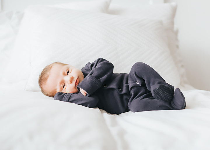 Child wearing Organic Snap Footie in Navy.