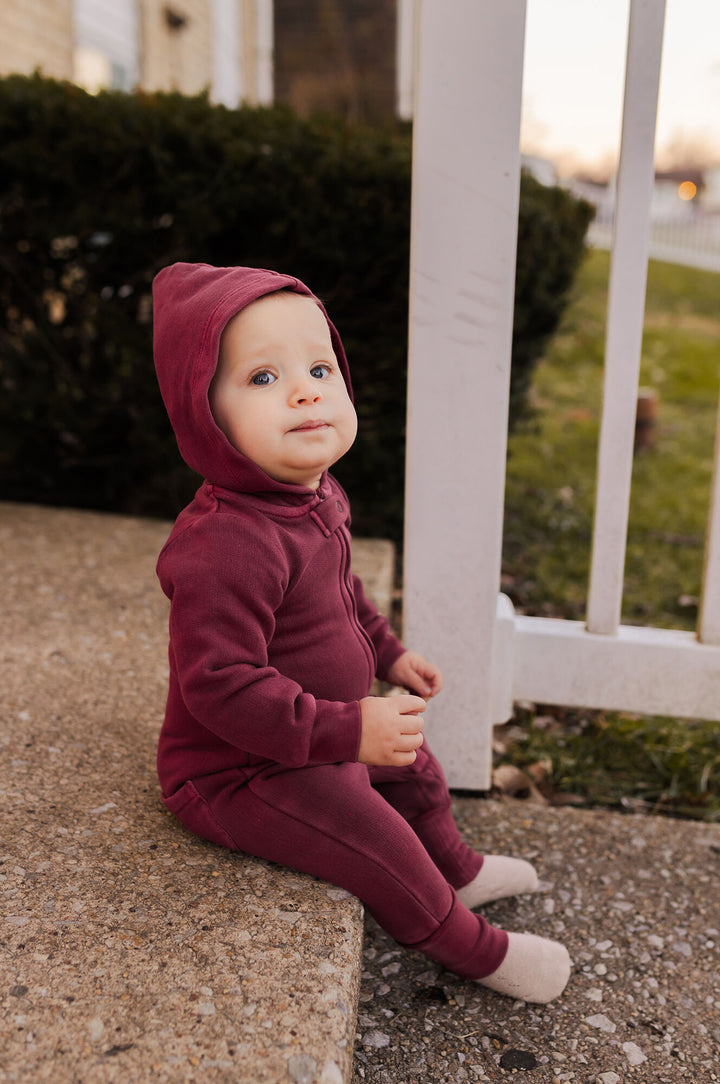 Child wearing Organic Cozy Zipper Romper in Sugarplum.