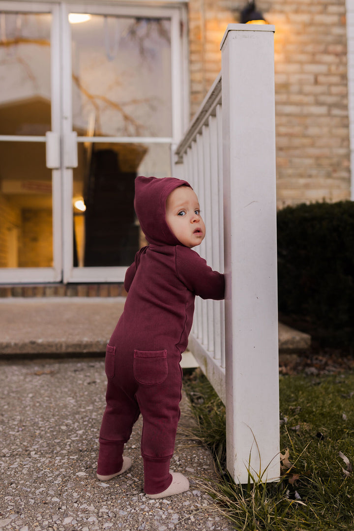 Child wearing Organic Cozy Zipper Romper in Sugarplum.