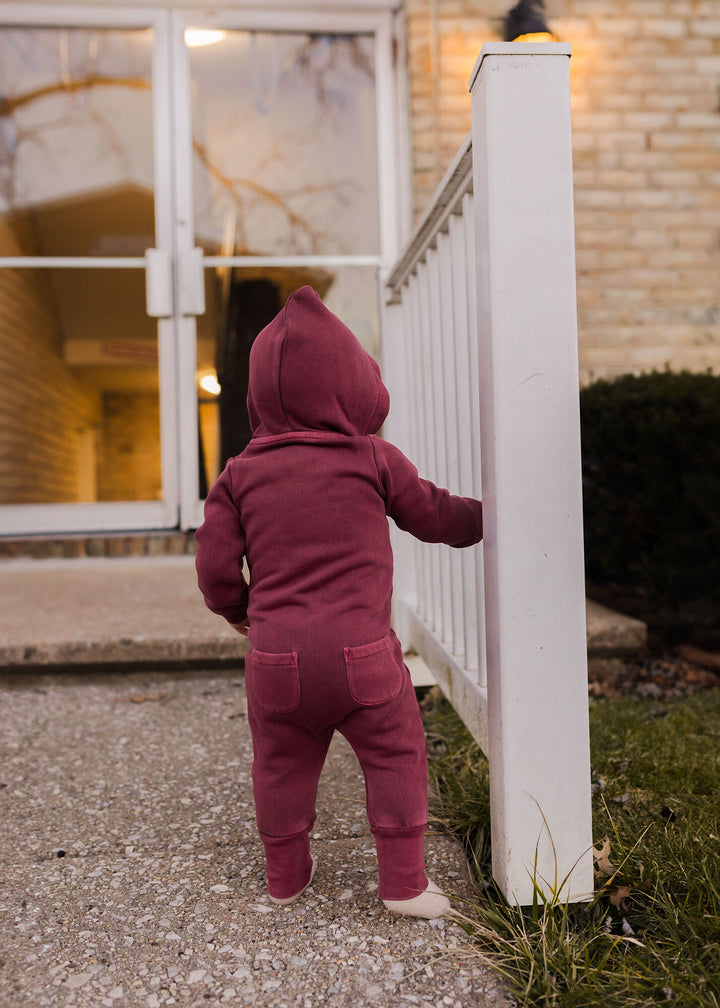 Child wearing Organic Cozy Zipper Romper in Sugarplum.