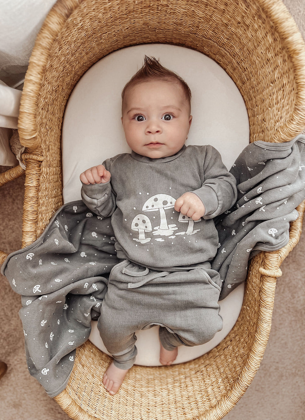 Child wearing Organic Cozy Blanket in Mist Mushrooms.