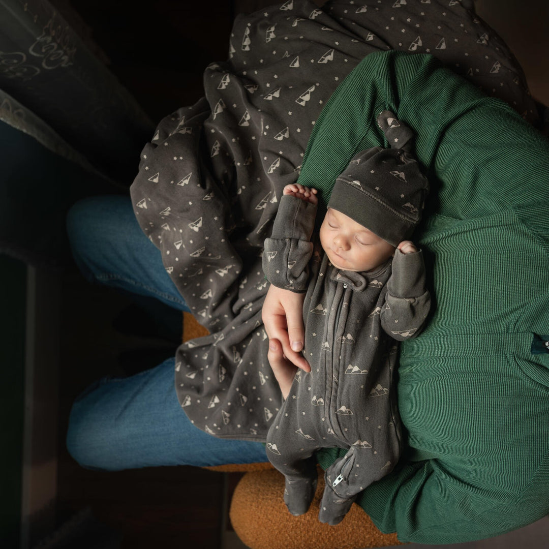 Child wearing Organic Cozy Top-Knot Hat in Bark Mountains.