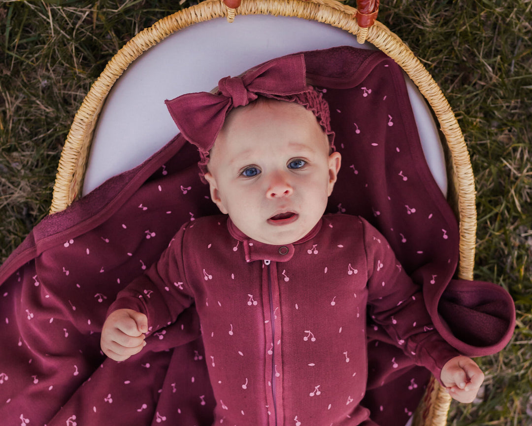 Child wearing Organic Cozy 2-Way Zipper Footie in Sugarplum Cherries.