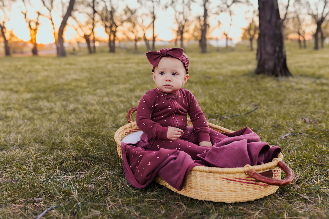 Child wearing Organic Cozy 2-Way Zipper Footie in Sugarplum Cherries.