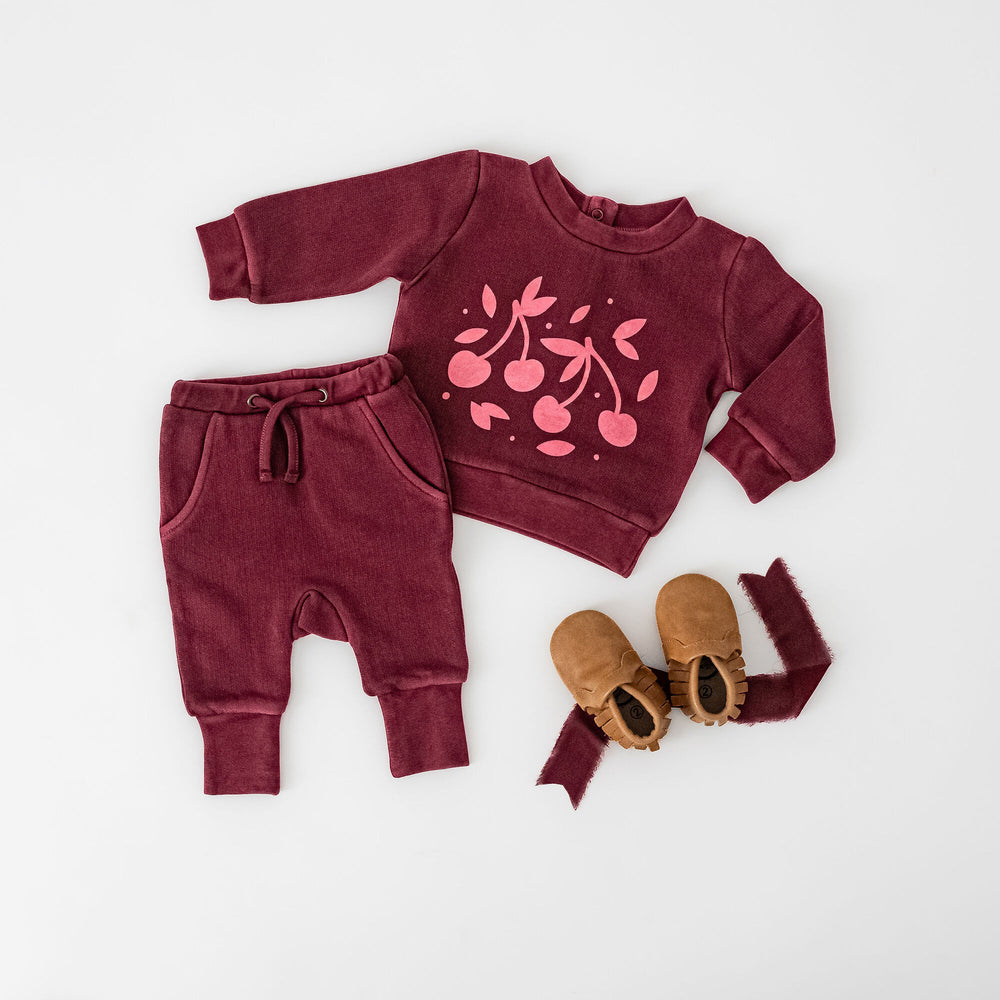 Child wearing Organic Cozy Graphic Sweatshirt & Jogger Set in Sugarplum Cherries.