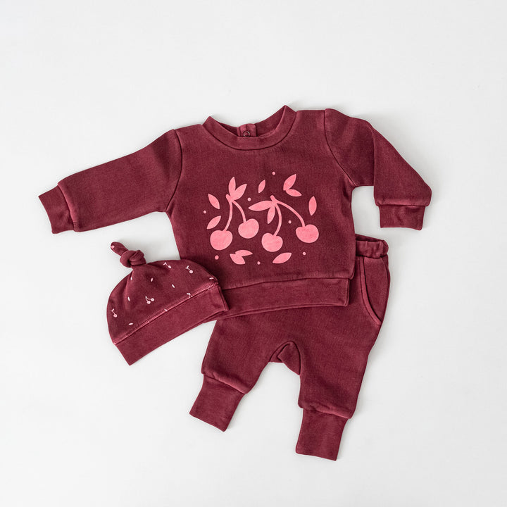 Child wearing Organic Cozy Graphic Sweatshirt & Jogger Set in Sugarplum Cherries.