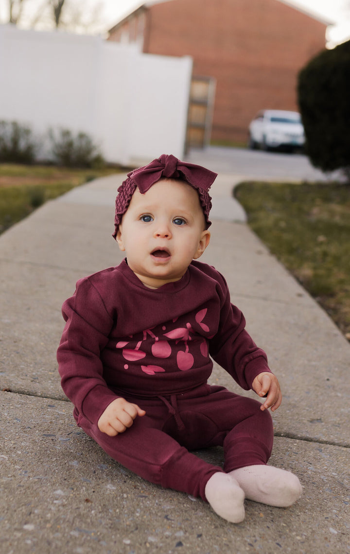 Child wearing Organic Cozy Graphic Sweatshirt & Jogger Set in Sugarplum Cherries.