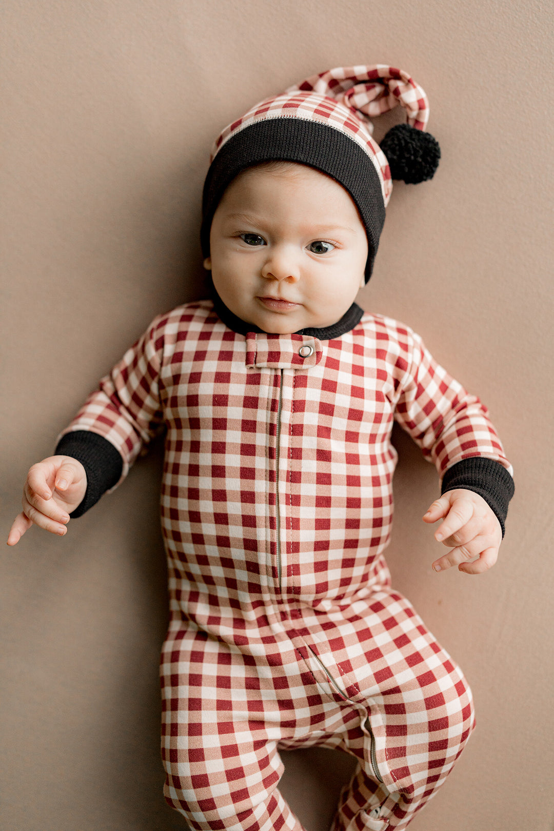 Child wearing Holiday 2-Way Zipper Footie & Cap Set in Crimson Plaid.