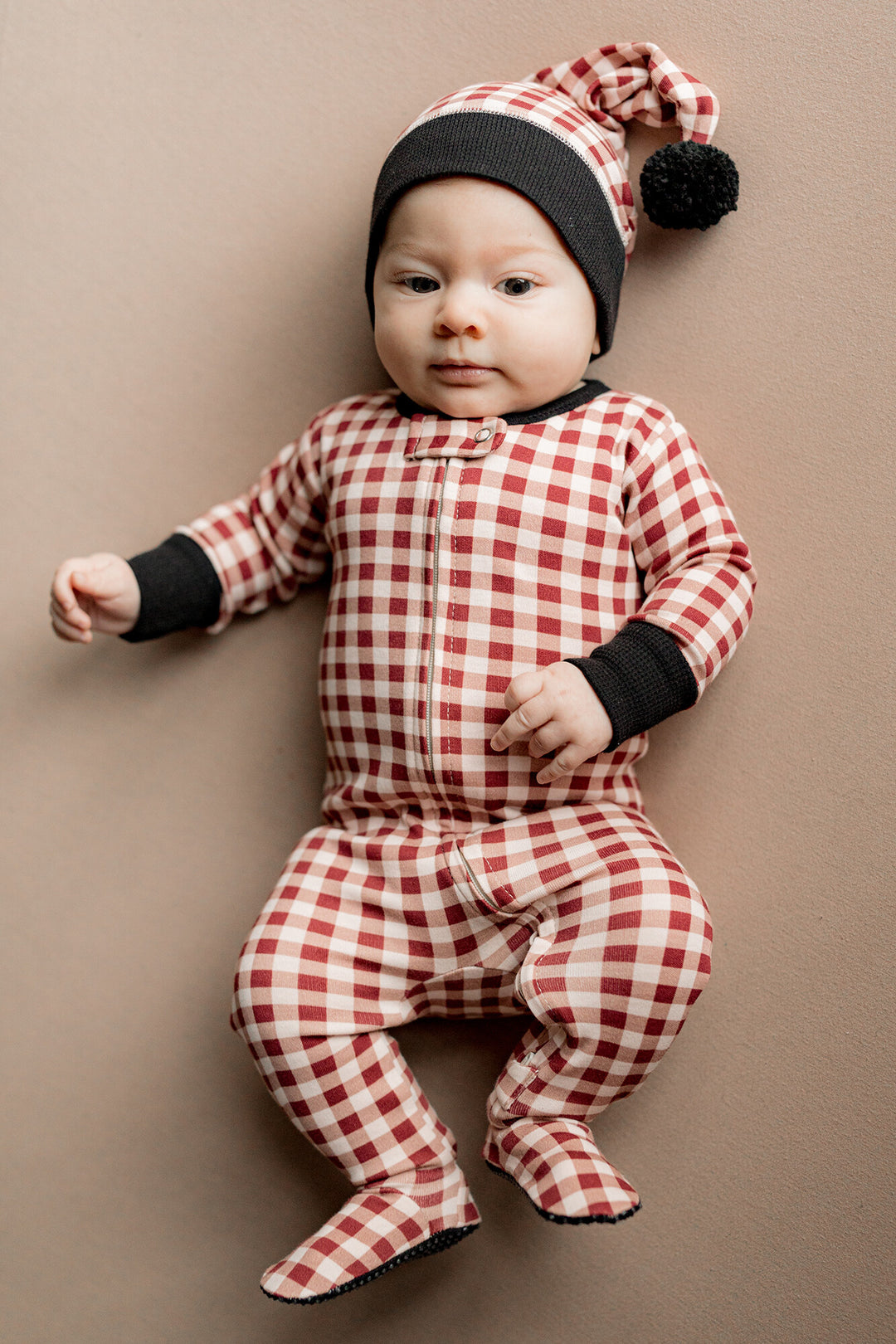 Child wearing Holiday 2-Way Zipper Footie & Cap Set in Crimson Plaid.