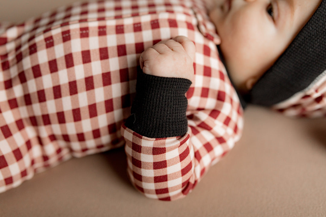 Child wearing Holiday 2-Way Zipper Footie & Cap Set in Crimson Plaid.