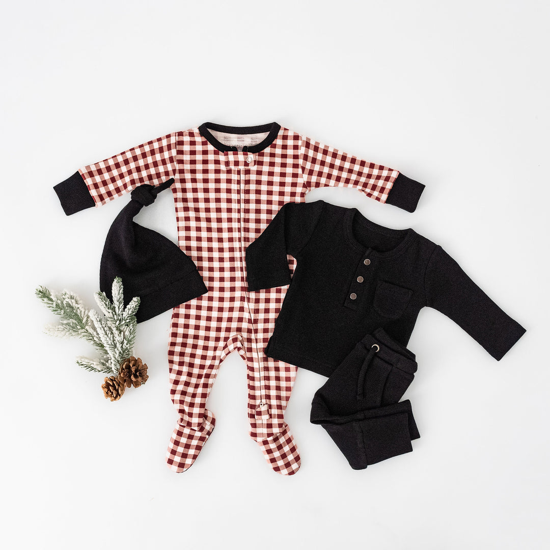 Child wearing Holiday 2-Way Zipper Footie & Cap Set in Crimson Plaid.