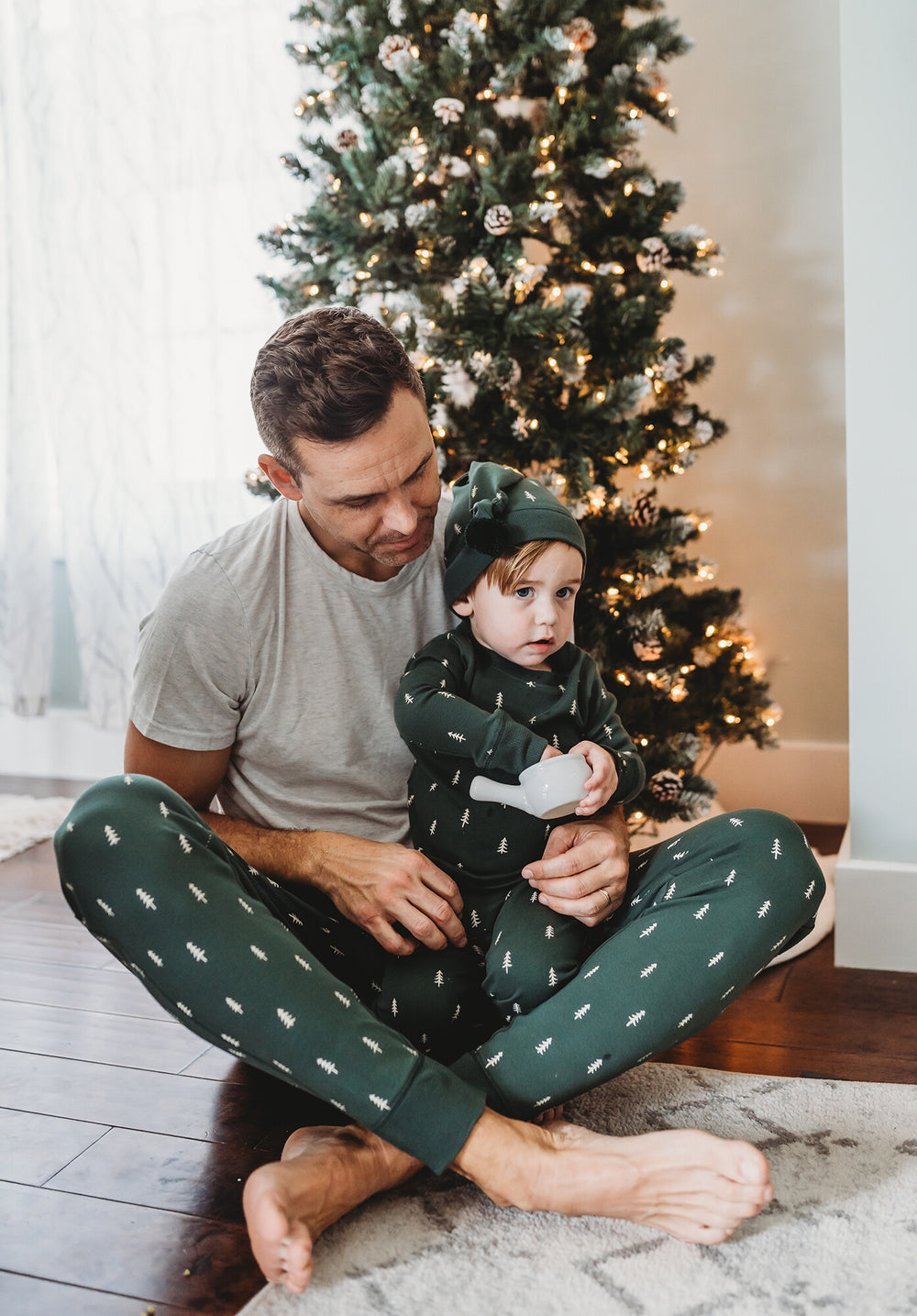 Child wearing Kids' Organic Holiday PJ & Cap Set in Pine Trees.