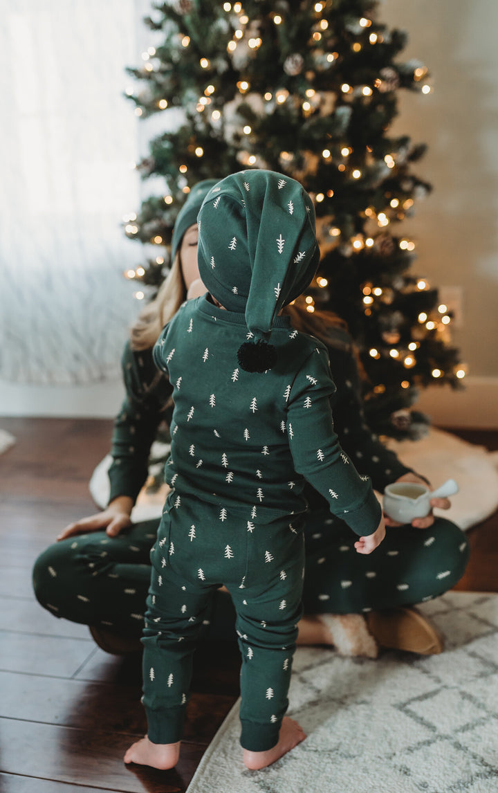 Child wearing Kids' Organic Holiday PJ & Cap Set in Pine Trees.