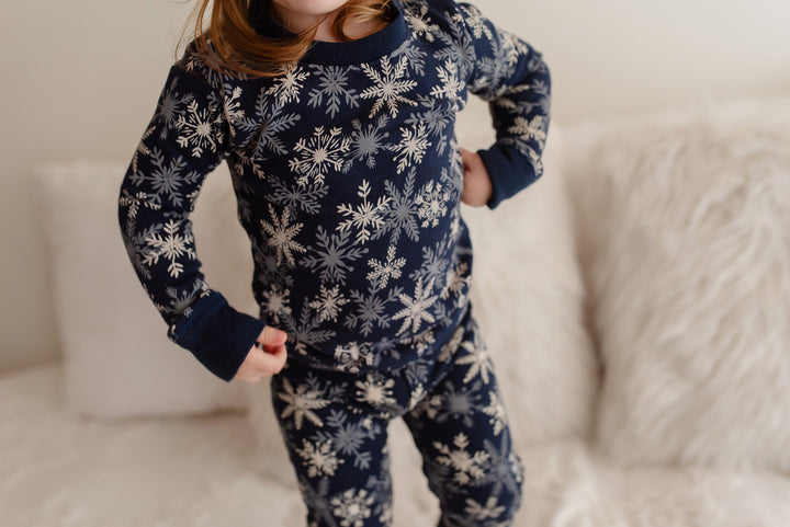 Child wearing Kids' Organic Holiday PJ & Cap Set in Snowflakes.