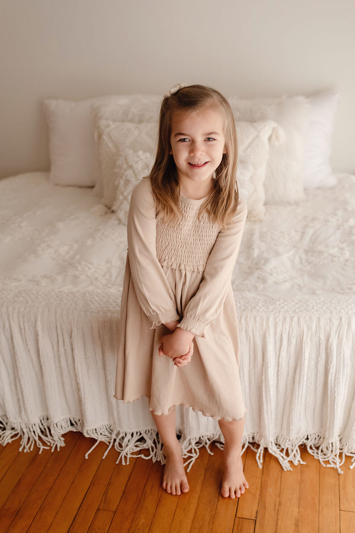 Child wearing Kid's Organic Smocked Dress in Oatmeal.