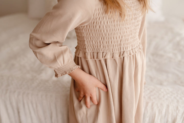 Child wearing Kid's Organic Smocked Dress in Oatmeal.