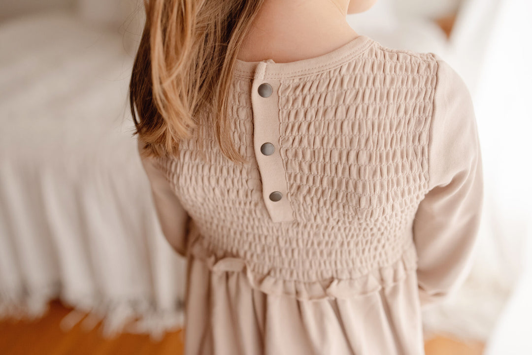 Child wearing Kid's Organic Smocked Dress in Oatmeal.