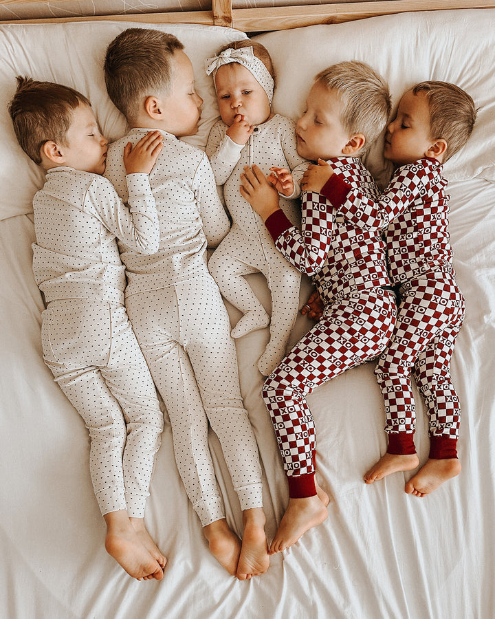 Child wearing Kids' Organic L/Sleeve PJ Set in Crimson Mini Hearts.