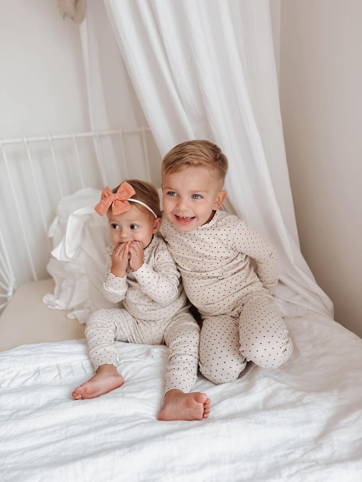 Child wearing Kids' Organic L/Sleeve PJ Set in Crimson Mini Hearts.