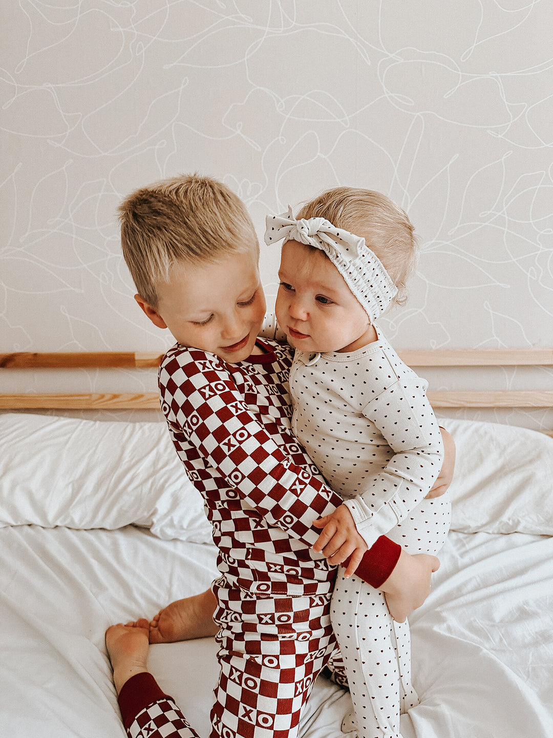 Child wearing Kids' Organic L/Sleeve PJ Set in Crimson XO Checker.