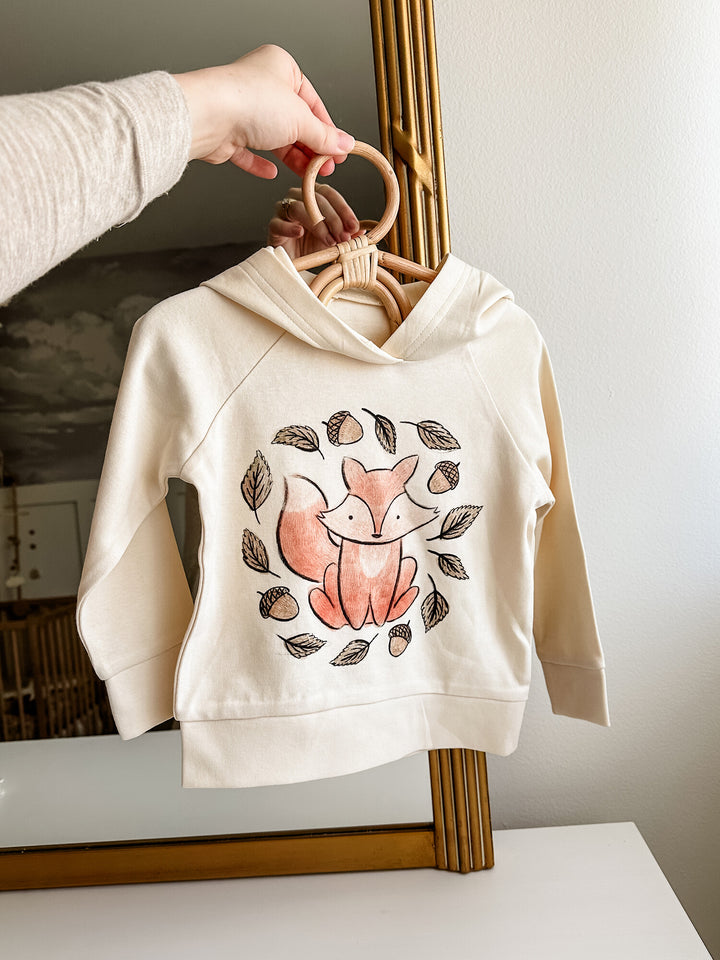 Child wearing Kids' Organic Printed Raglan Hoodie in Foxy Graphic.