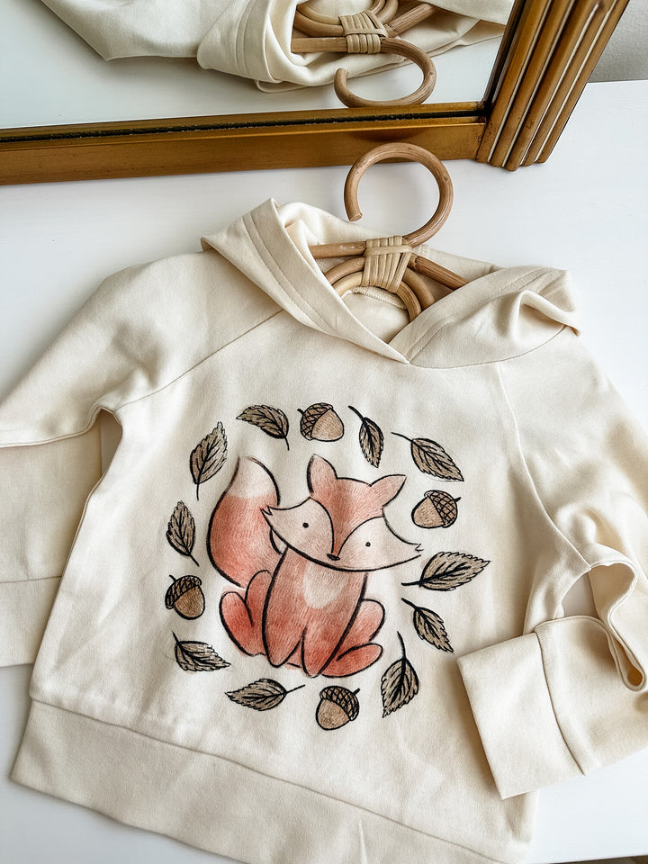 Child wearing Kids' Organic Printed Raglan Hoodie in Foxy Graphic.