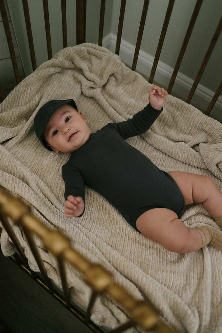 Child wearing Organic Mock-Neck Bodysuit in Charcoal.