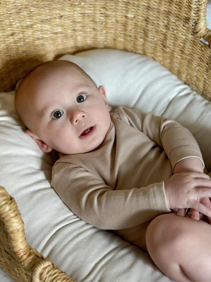 Child wearing Organic Mock-Neck Bodysuit in Oatmeal.