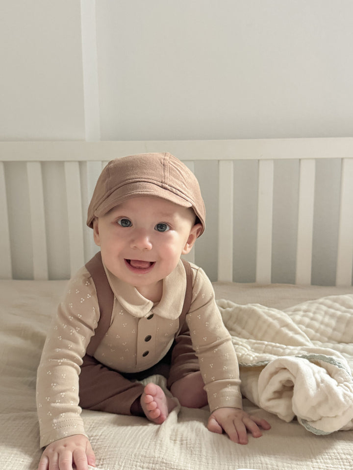 Child wearing Organic Polo Bodysuit in Oatmeal Dots.