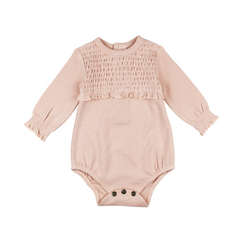 Organic Smocked Chest Bodysuit in Rosewater, a light pink color .