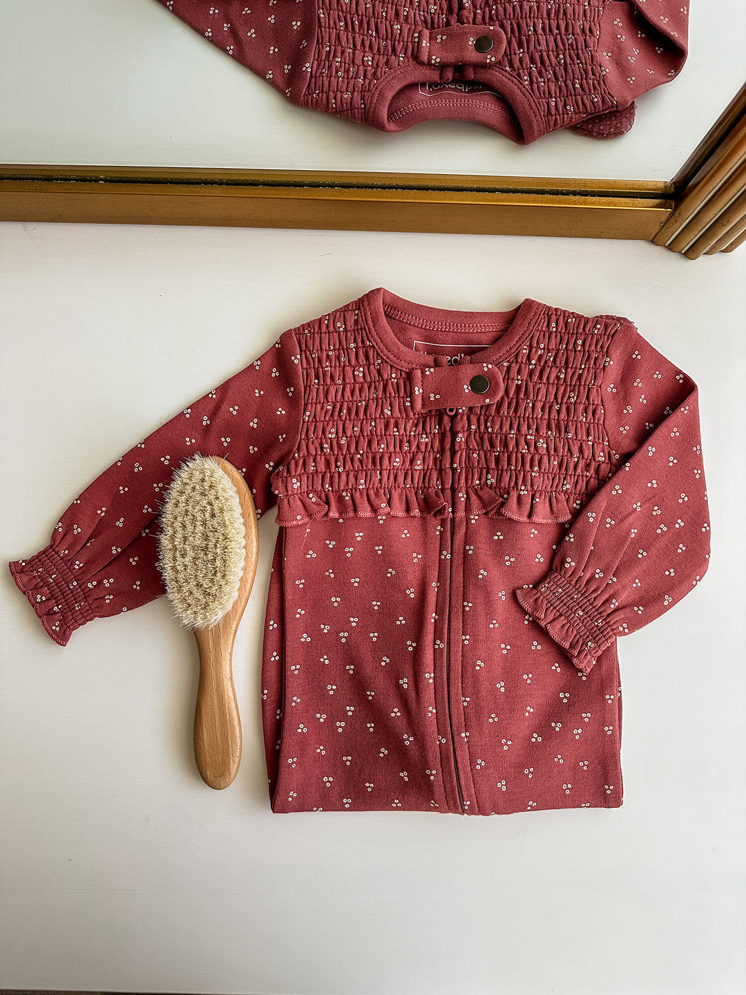 Child wearing Organic Smocked Zipper Footie in Appleberry Dots.