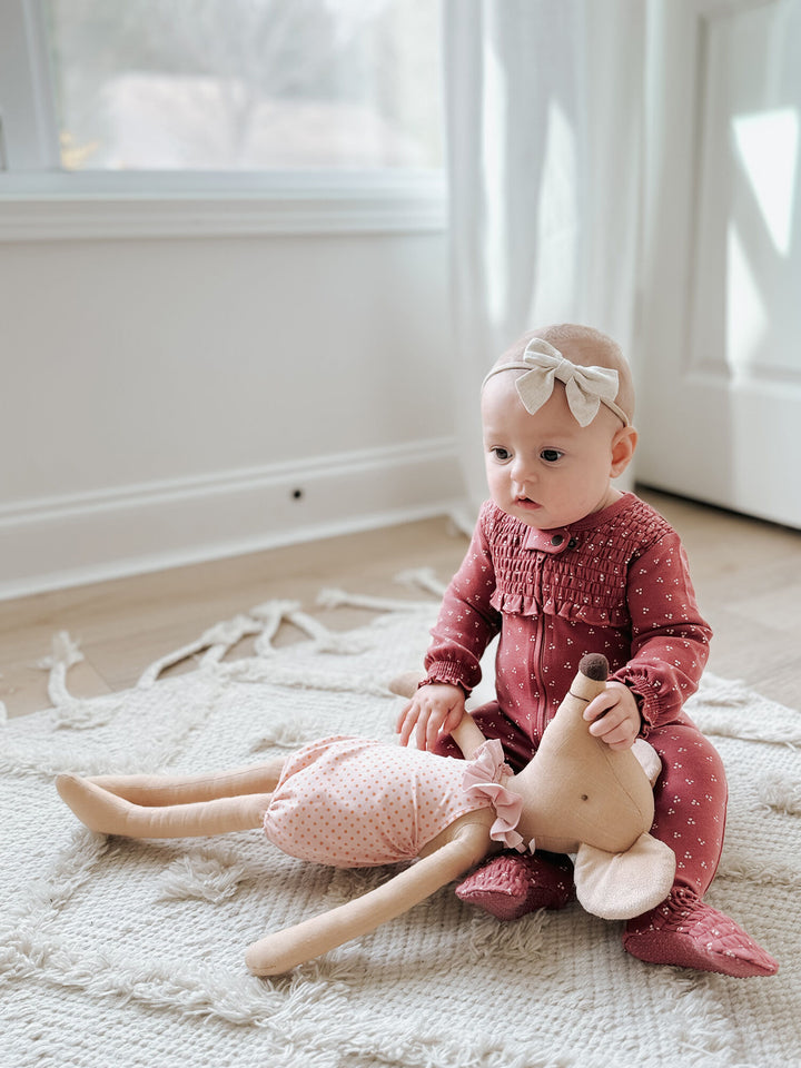 Child wearing Organic Smocked Zipper Footie in Appleberry Dots.