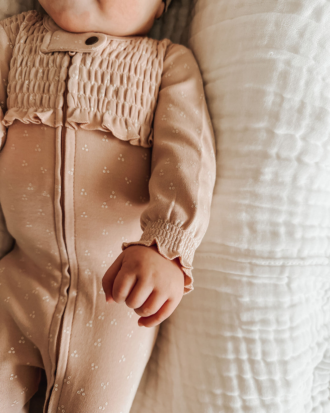 Child wearing Organic Smocked Zipper Footie in Oatmeal Dots.