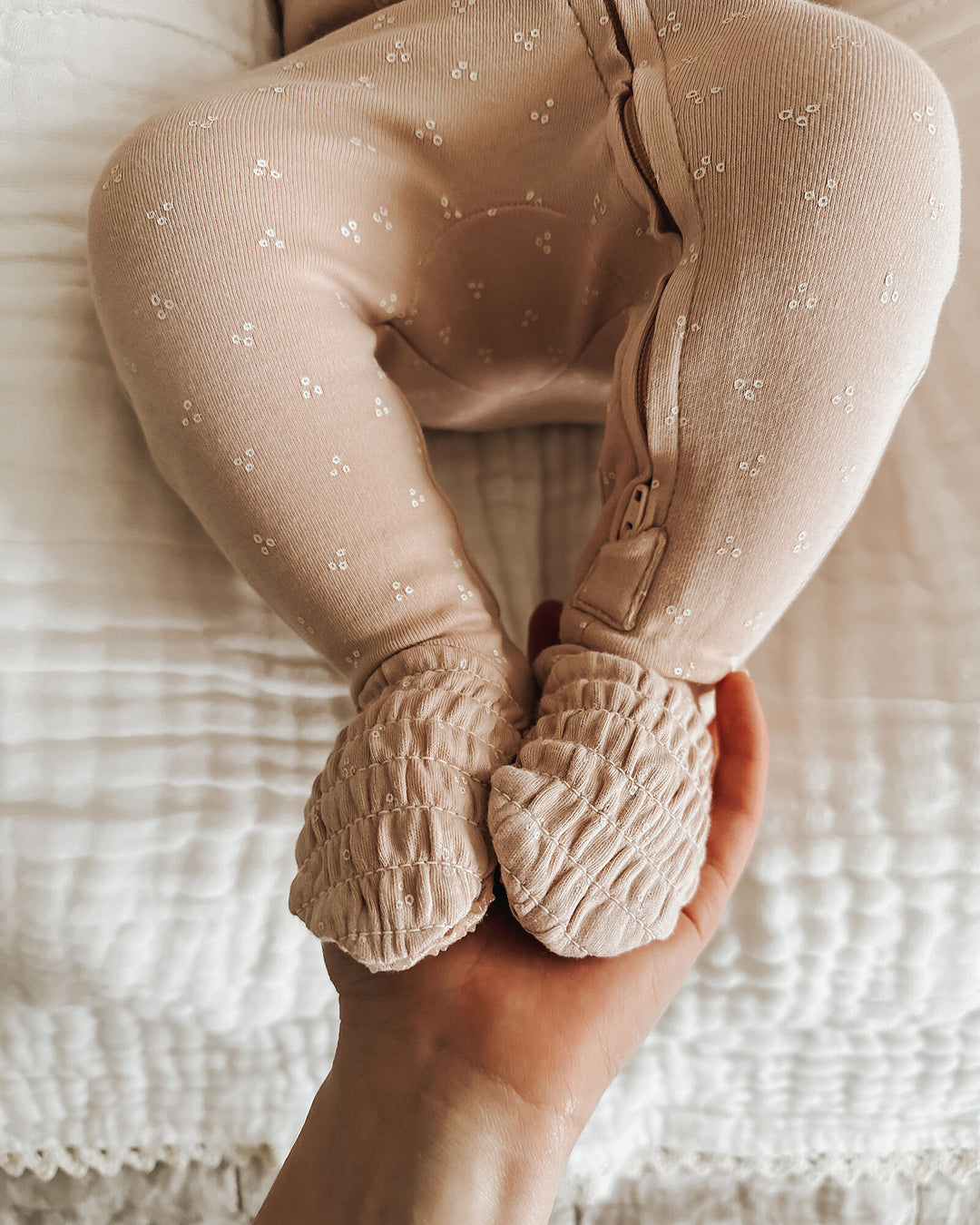 Child wearing Organic Smocked Zipper Footie in Oatmeal Dots.