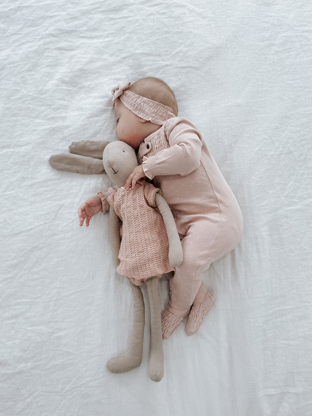 Child wearing Organic Smocked Zipper Footie in Rosewater Dots.