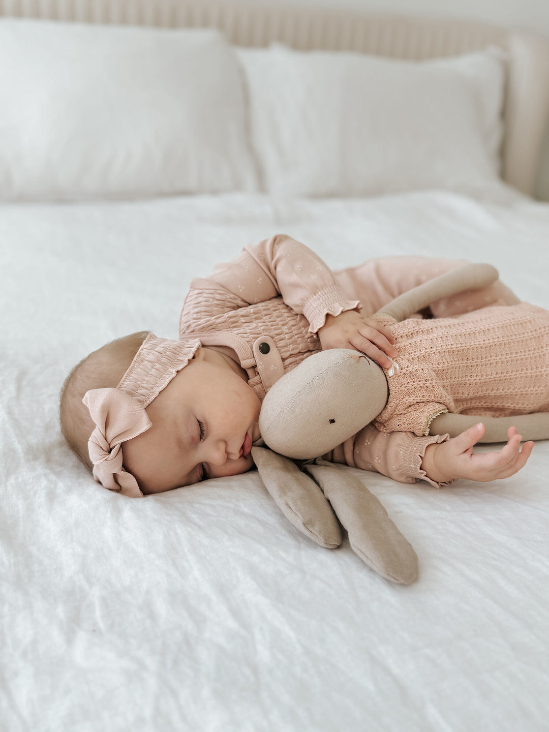 Child wearing Organic Smocked Zipper Footie in Rosewater Dots.