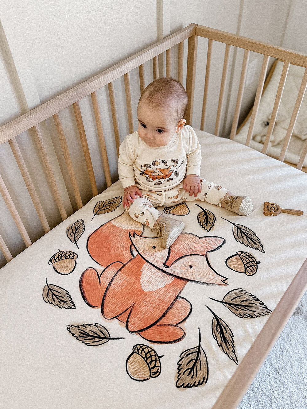 Child wearing Organic Crib Sheets in Foxy Graphic.