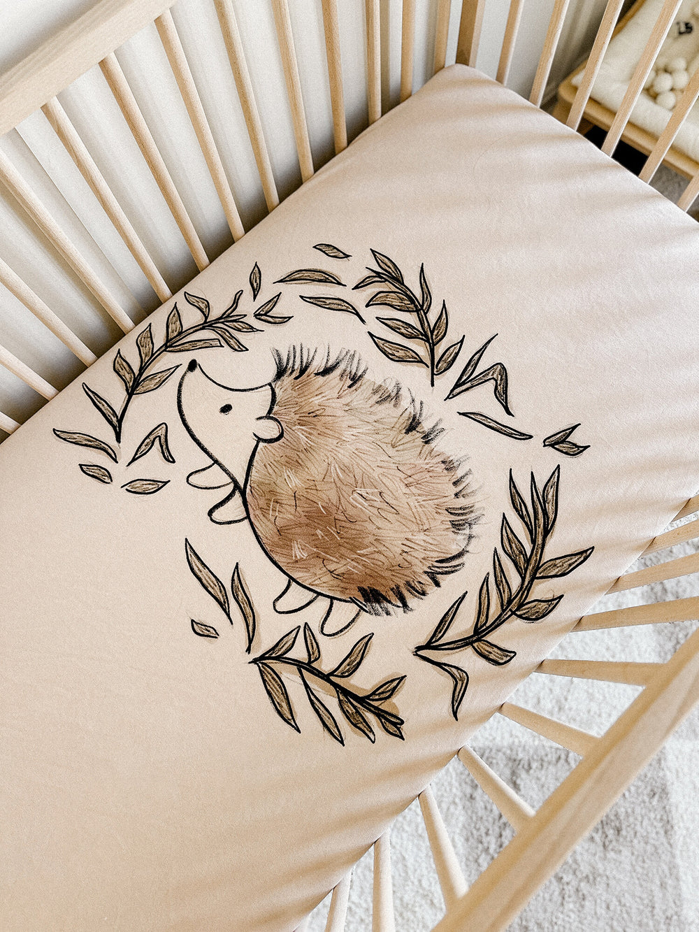 Child wearing Organic Crib Sheets in Prickles Graphic.