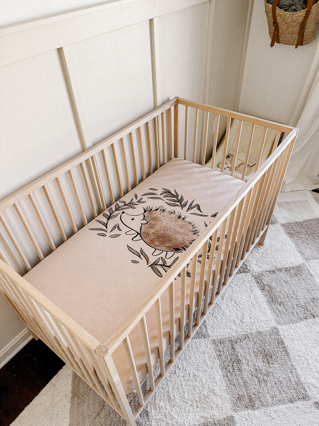 Child wearing Organic Crib Sheets in Prickles Graphic.