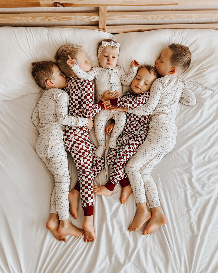 Child wearing Organic 2-Way Zipper Footie in Crimson Mini Hearts.