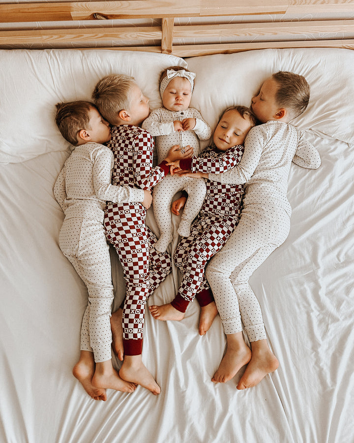 Child wearing Organic 2-Way Zipper Footie in Crimson Mini Hearts.