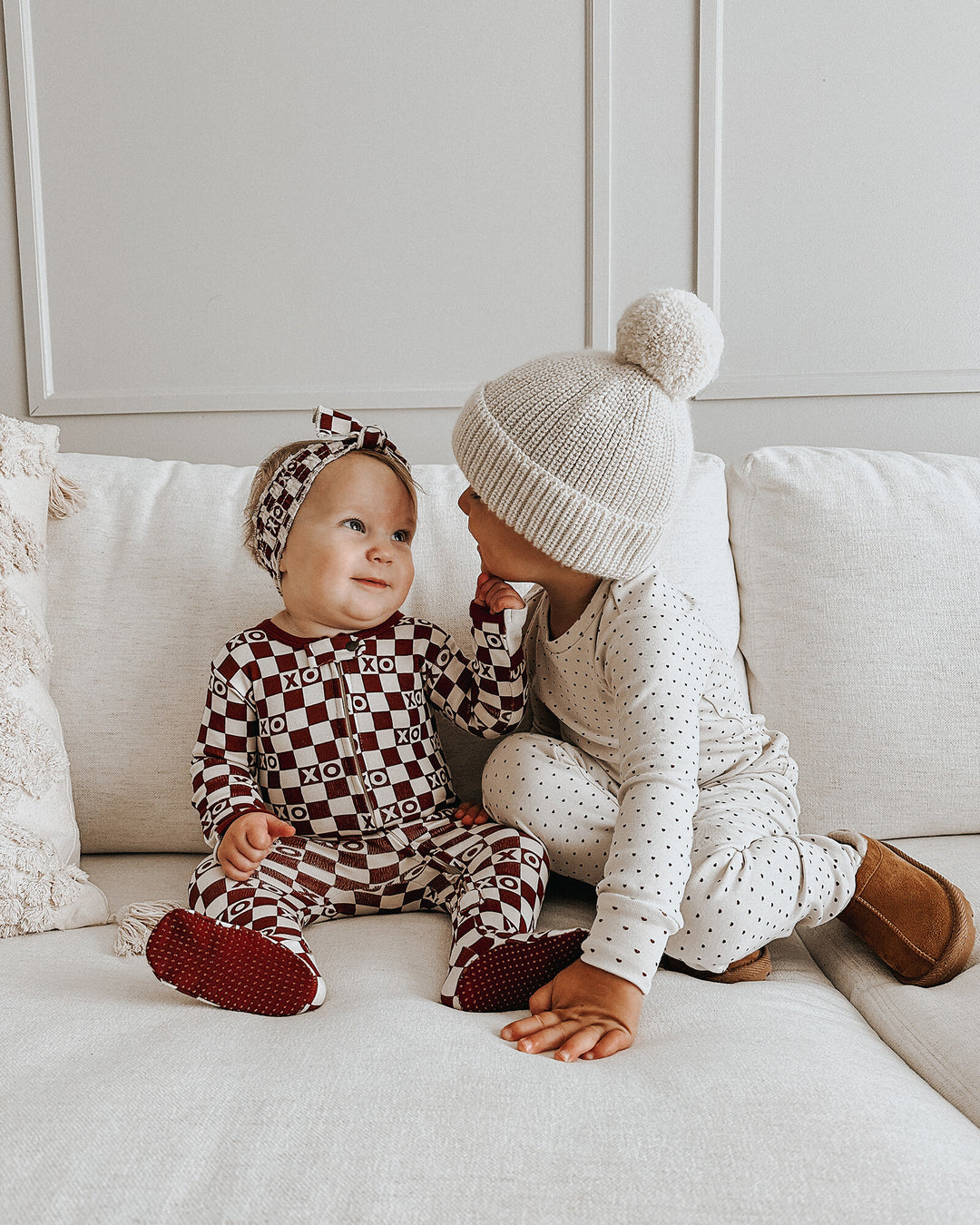 Child wearing Organic 2-Way Zipper Footie in Crimson XO Checker.