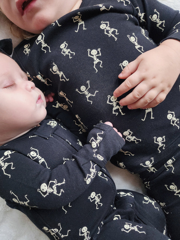 Child wearing Organic 2-Way Zipper Footie in Dancing Skeletons.