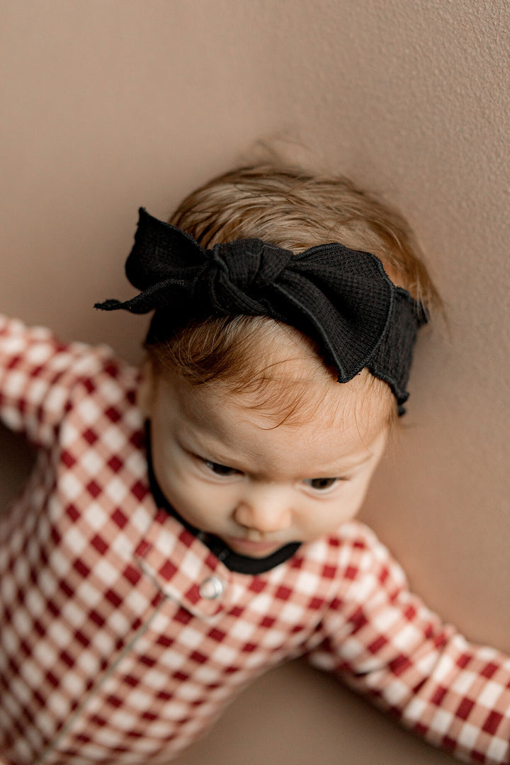 Child wearing Organic Thermal Smocked Headband in Black.