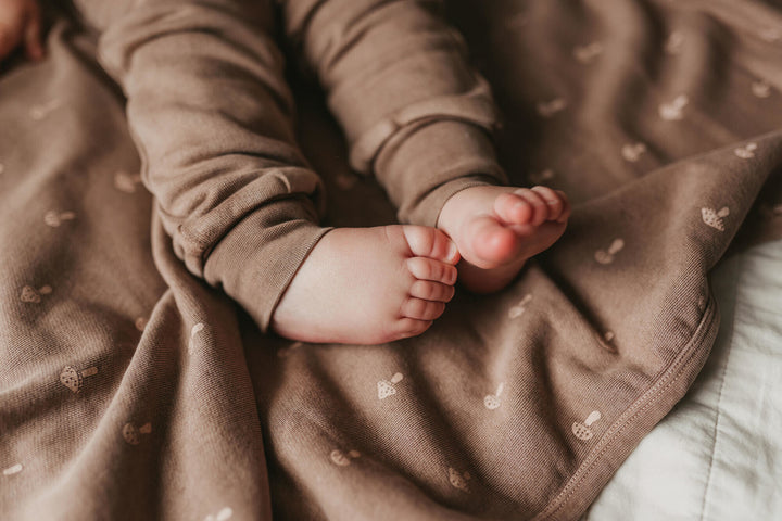 Child wearing Organic Cozy Blanket in Umber Mushroom.