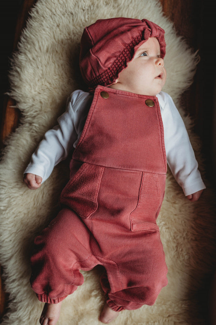 Child wearing French Terry Overall Romper in Appleberry.