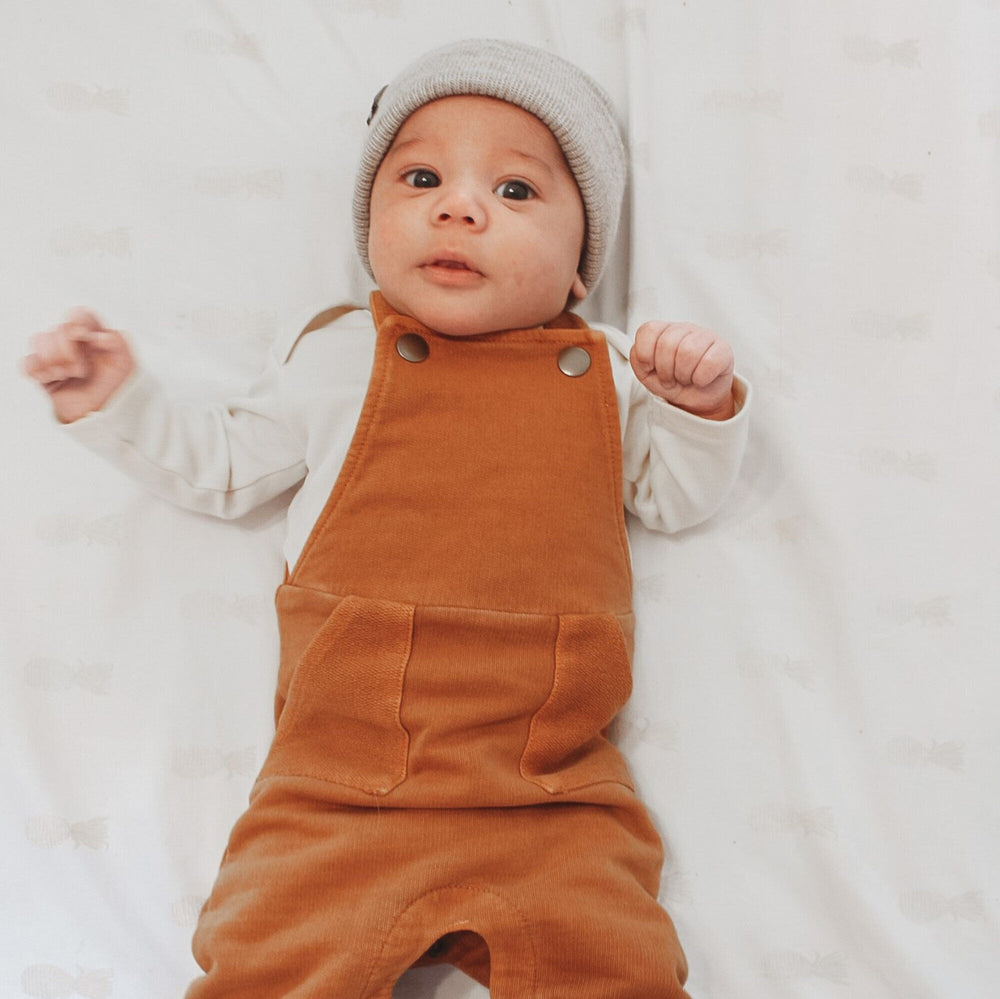 Child wearing French Terry Overall Romper in Butterscotch.