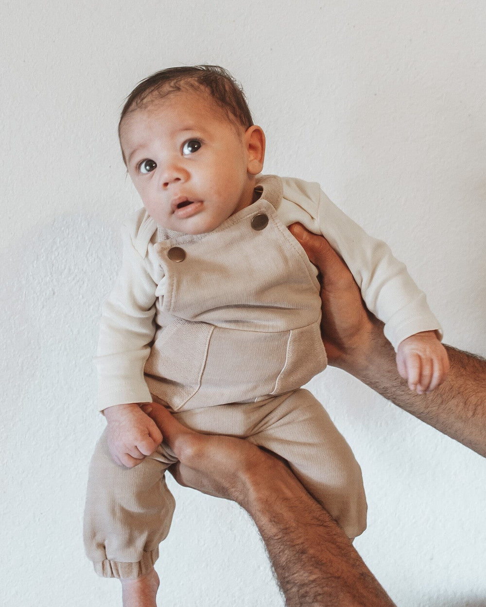 Child wearing French Terry Overall Romper in Oatmeal.