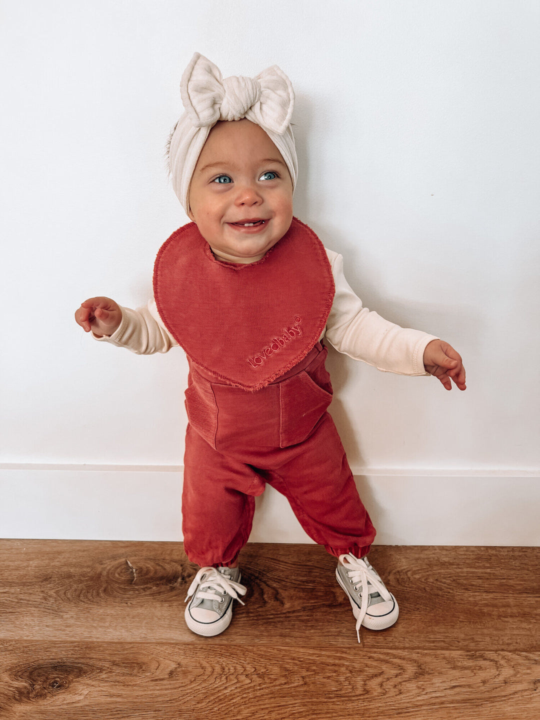 Child wearing French Terry Reversible Bib in Appleberry.